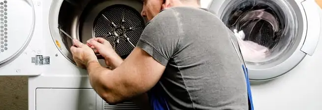 Dryer repair technician fixing a clothes dryer drum in Wilmington, NC