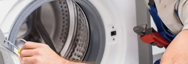 Appliance technician repairing a clothes dryer drum and internal parts in Wilmington, NC