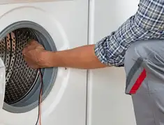 Dryer repair technician diagnosing and servicing a clothes dryer in Wilmington, NC
