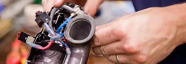 Vacuum repair technician reconnecting wiring and components in Wilmington, NC