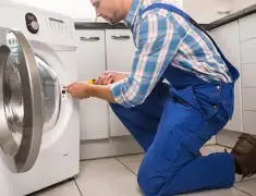 Washing machine repair technician servicing a front-load washer in Wilmington, NC
