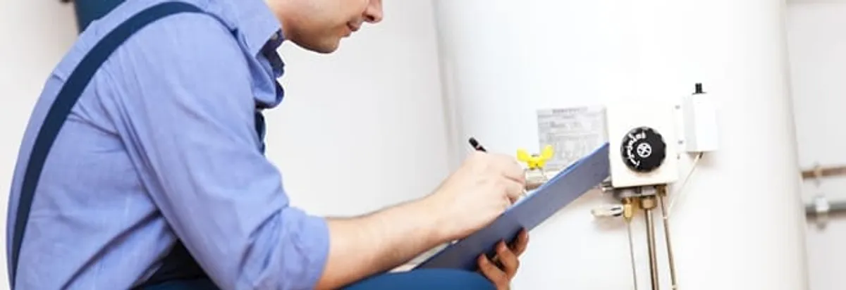 Water heater repair technician inspecting the unit and recording service notes in Wilmington, NC