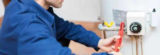 Water heater repair technician adjusting the temperature control and gas valve in Wilmington, NC